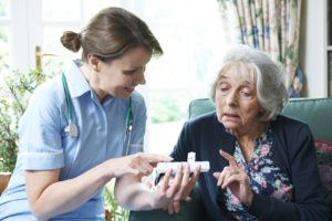 Nurse Advising Senior Woman On Medication At Home